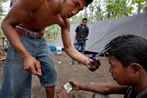 148934889-man-having-his-hair-cut-in-jungle-camp-gettyimages